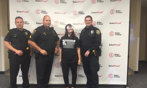 Binge Effects Event with teenage girl posing with officers for the Alcohol Liability Initiative Coalition